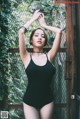 A woman in a black bathing suit posing for a picture.