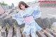 A woman in a blue and white kimono is standing on some steps.