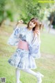 A woman in a blue and white kimono is posing for a picture.