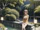 A woman sitting on a stone wall next to a pond.