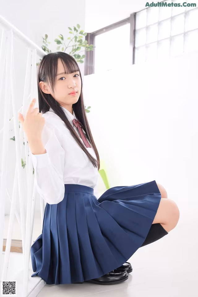 A young woman in a school uniform posing for a picture.