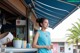 A woman standing at a counter in front of a restaurant.