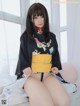 A woman in a black and yellow kimono sitting on a bed.