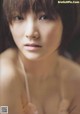 A naked asian woman with short hair and bangs.